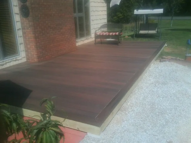 Freshly stained wood deck built against a brick home in Bethany
