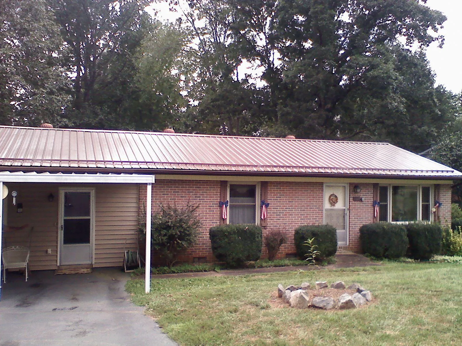 Bronze metal roof and carport on a brick ranch home — Roof Repair work by our crew in Bethany